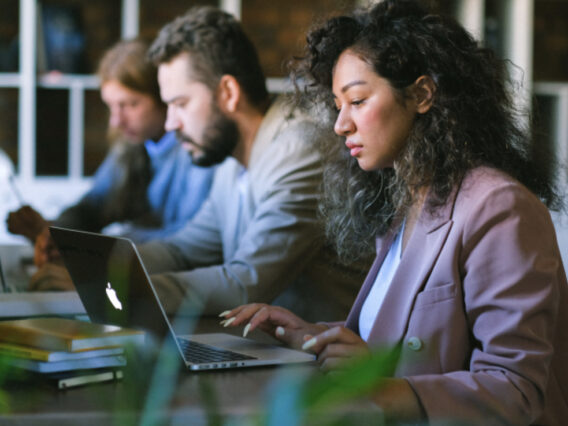 Company employees work on laptops.